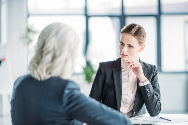 3 Conducting A Performance Review Business women discussing project RS John Larrere Consulting LLC